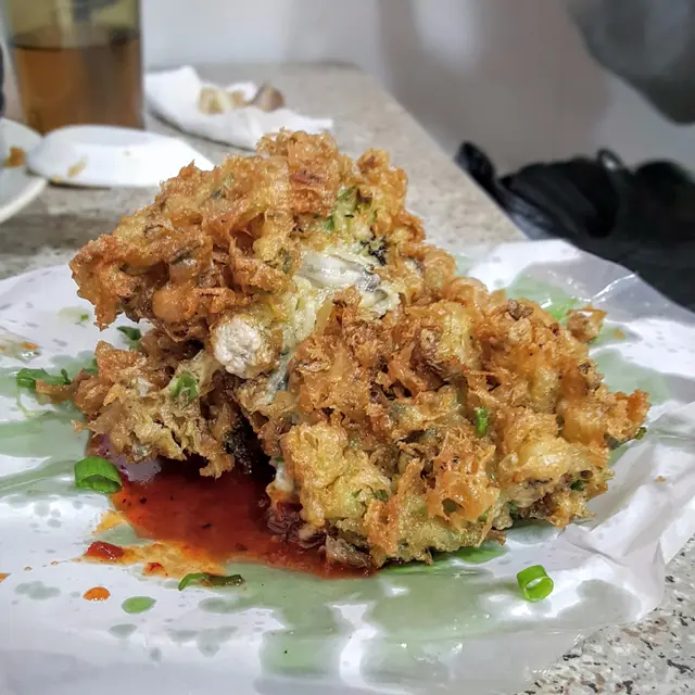 看到門外阿姨給力煎蠔餅，所以滿心期待，但事與願違。蠔餅看不上是煎蠔餅，像蠔山或者是炸蠔，與＜餅＞不太相近，蠔餅下面附上辣椒醬。蠔餅太油膩，像渴油，麵粉太多，蠔太少，像是吃炸粉的感覺，味道太奇怪。