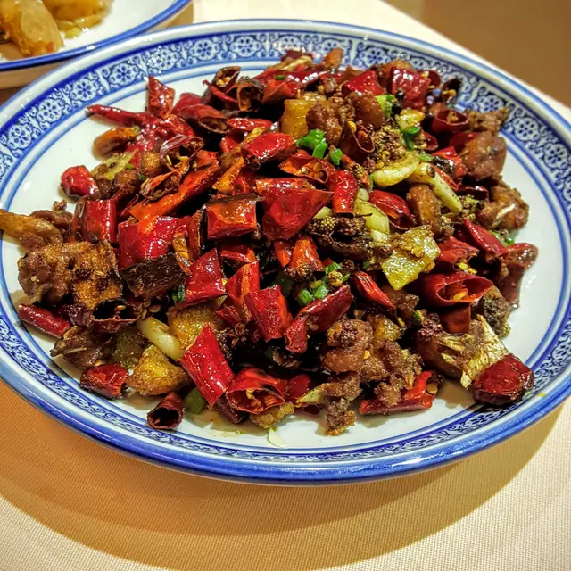 用大量的辣椒和花椒去炒雞,帶骨的雞肉切成小粒,之後香炸,炸至香脆,加入辣椒和花椒再炒,雞肉帶一點骨,但已經炸到香脆,可以連骨吃,炒過之後雞肉帶麻辣味,香脆加麻辣,風味十足,是伴飯件啤酒的好選擇