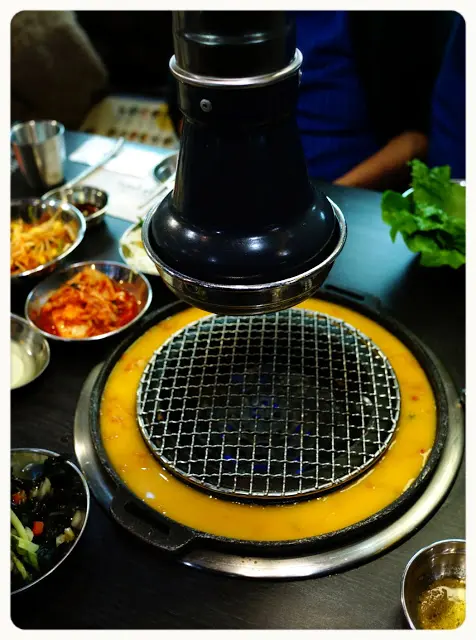 店員放入泡菜粒, 倒入蛋漿於爐邊慢慢煮熟, 這種食法新穎又有趣