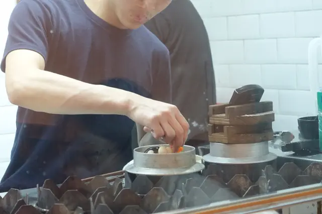 師傅小心翼翼把米、上湯及各類食材，放入鍋中蒸製