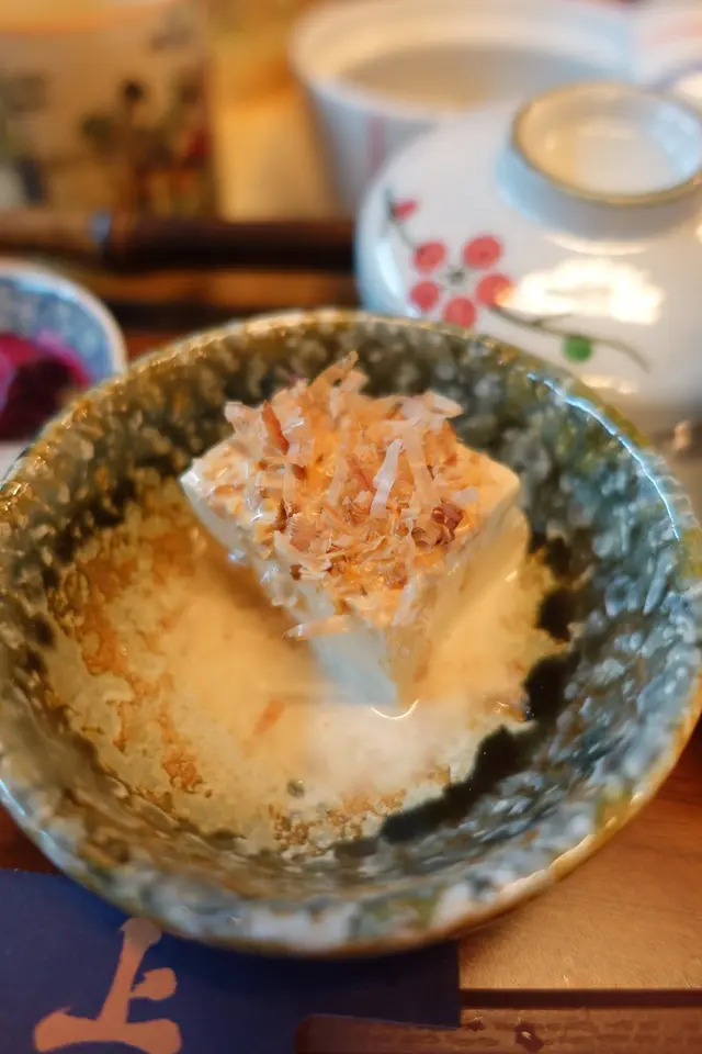 把芝麻醬及木魚絲放上滑溜而涼浸浸的豆腐，整體口味上富有層次感！