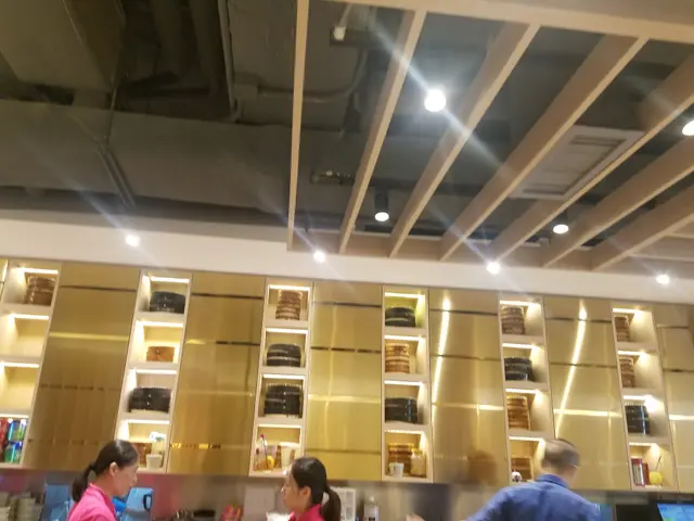 牆壁上凹陷方形的部份擺放著不同顏色及材料製造的飲食器皿