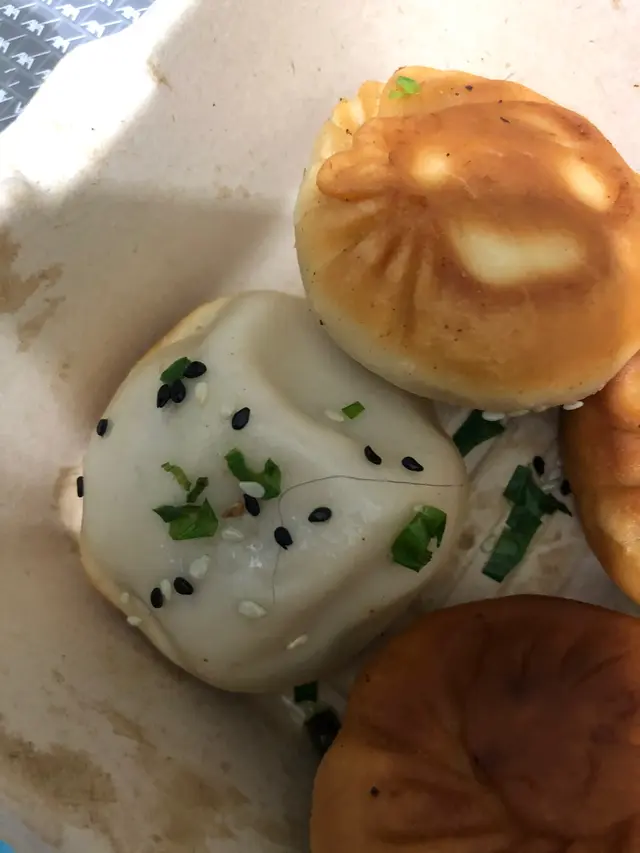 一打開個盒就見到有條毛髮喺生煎包上面