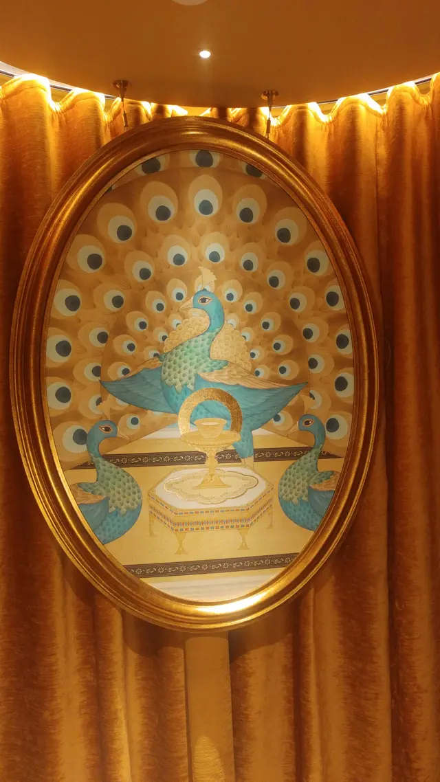 在知客身後的畫,孔雀顯貴氣