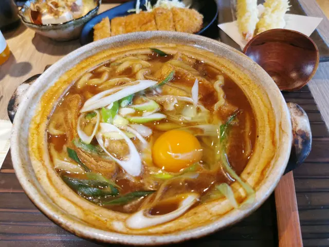 豬扒不夠鬆化,鍋內有生蛋、龍鬚菜、粗蔥段、魚板豆皮等配料。